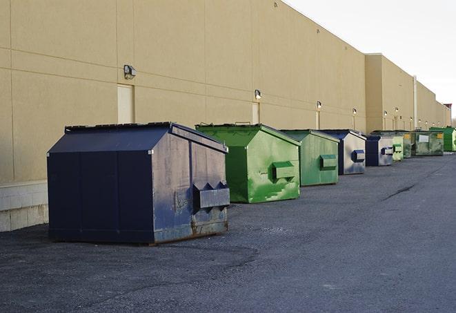 a construction worker empties a wheelbarrow of waste into the dumpster in Climax, NC